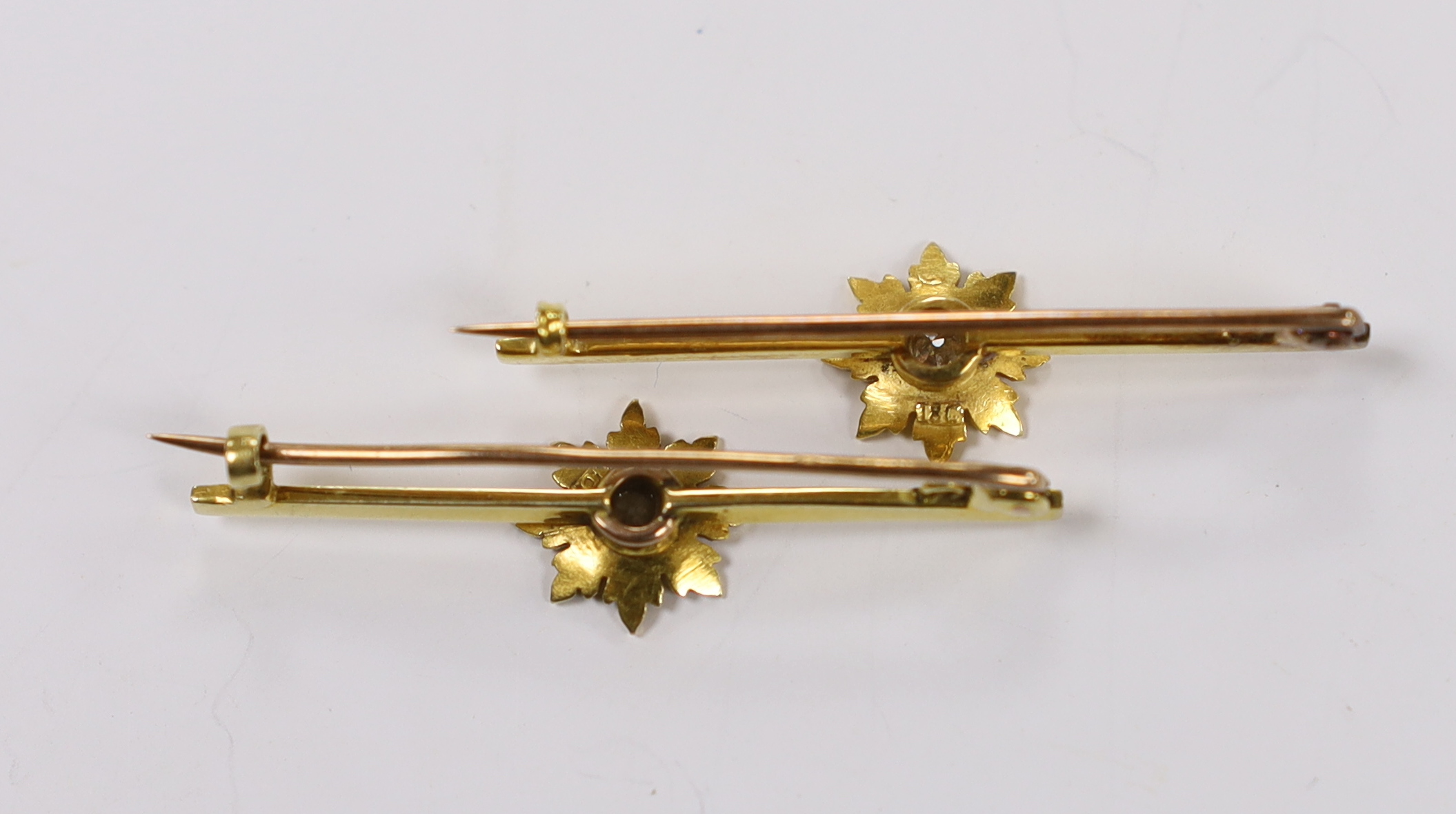A pair of early 20th century yellow metal and single stone diamond set flower head bar brooches, 44mm, gross weight 6.2 grams.